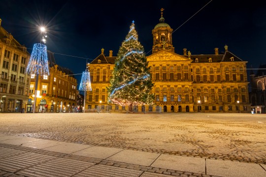 Navidad en la plaza Dam en Amsterdam por la noche en los Países Bajos